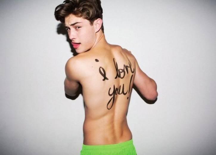 top runway model francisco lachowski shirtless wearing lime green shorts with i love you written in marker on his back