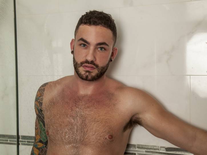Judas Cole is sweaty from his work out so he decides to shower off. Adrian is patiently waiting hard as a rock for him to finish. When Judas exits the shower, his fat shaft is at full attention. His hairy chest hovers over Adrian and they begin to kiss. They make out and then finally start to suck each other off. But Adrian needs his hole played with. Judas pulls out a toy and fucks him with it until they both cum buckets all over Adrian’s chest. Be sure to check out the free gay porn pics of the hot action here at Randy Blue.