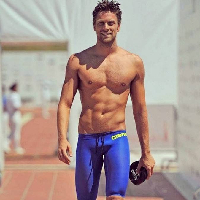Luca Dotto in his tight bathing suit, walking poolside