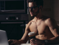 Fit Man Using Laptop and drink coffee at morning
