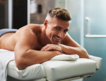 Handsome young man lying on massage table
