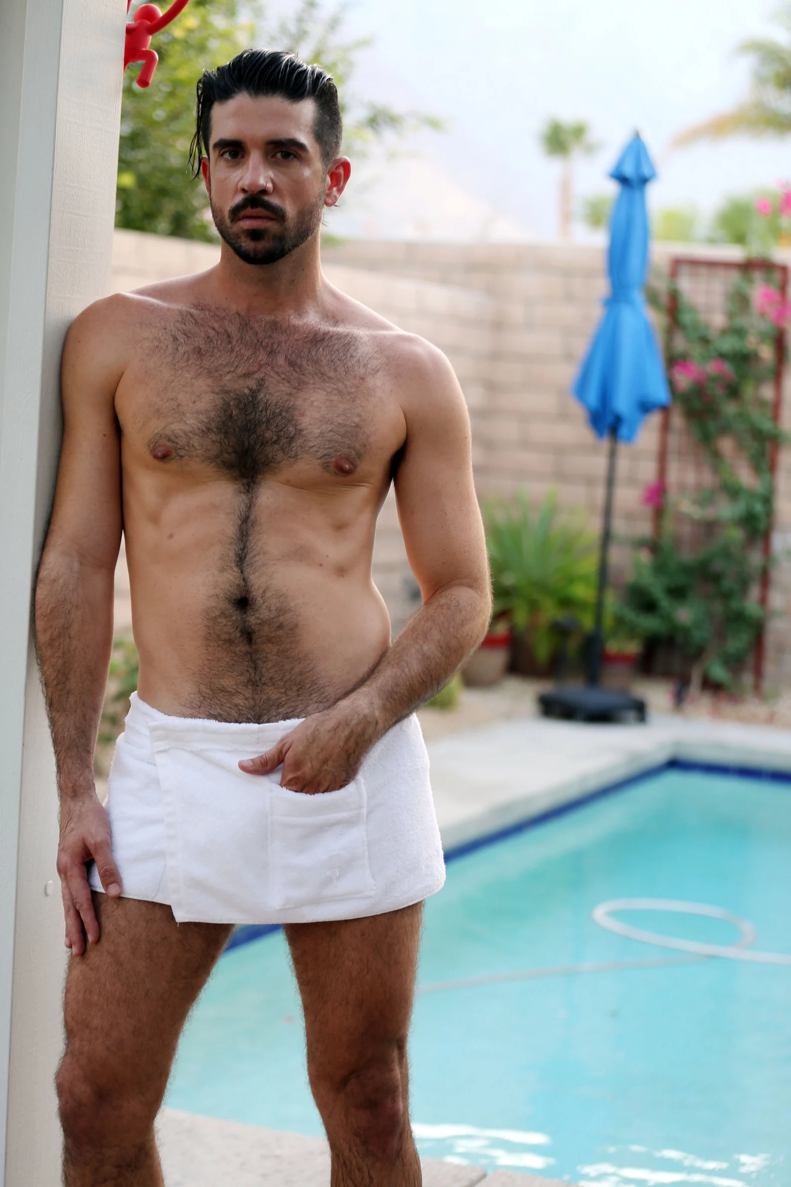 gay male model in palm springs wearing a short terrycloth towel with a velcro around the waistline