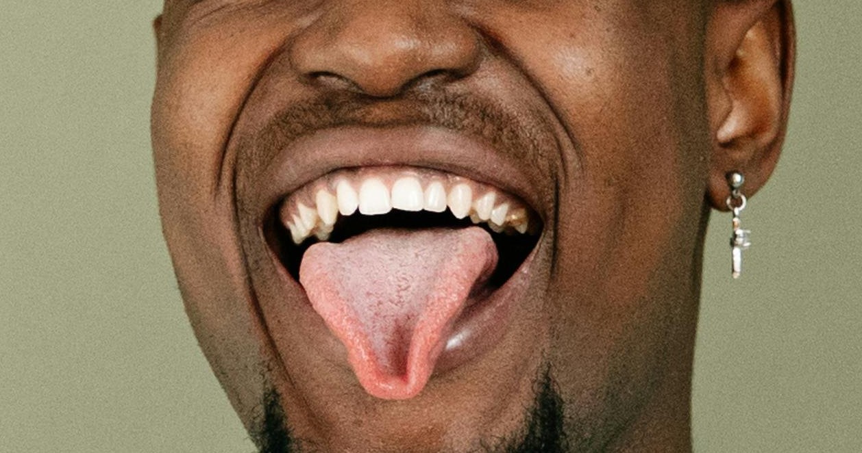 gay male sticking out his tongue and ready for gay hookup and gay sex fun via pexel Photo by Ivan Samkov