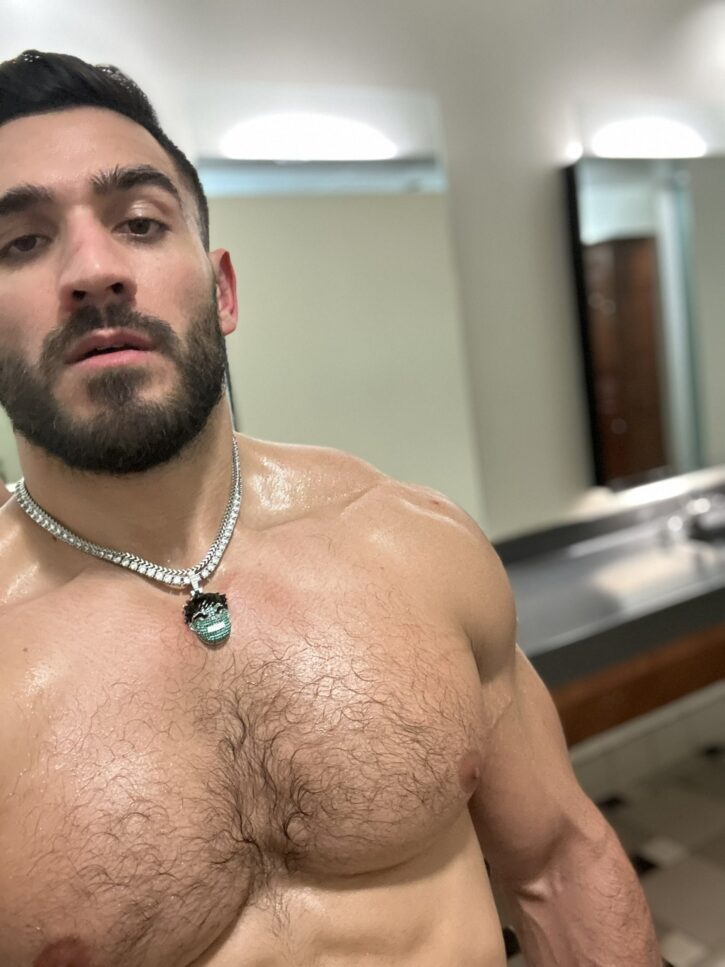 hairy chest muscle stud posing in gay locker room