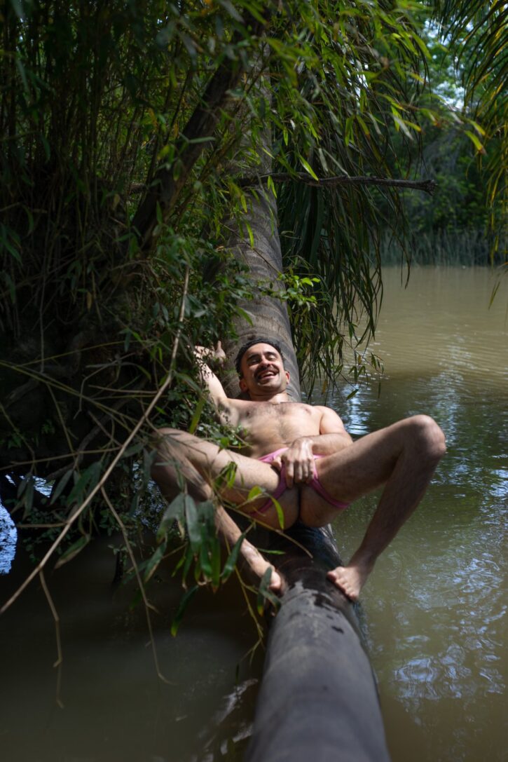 hairy twunk naked lying down outside on tree trunk grabbing cock