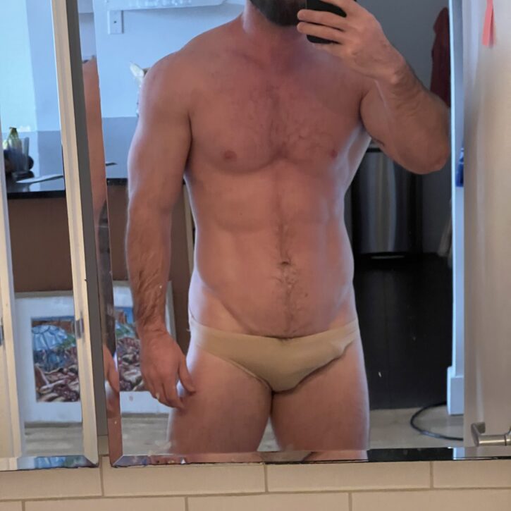gay muscle daddy selfie with hard dick tucked in skintight briefs