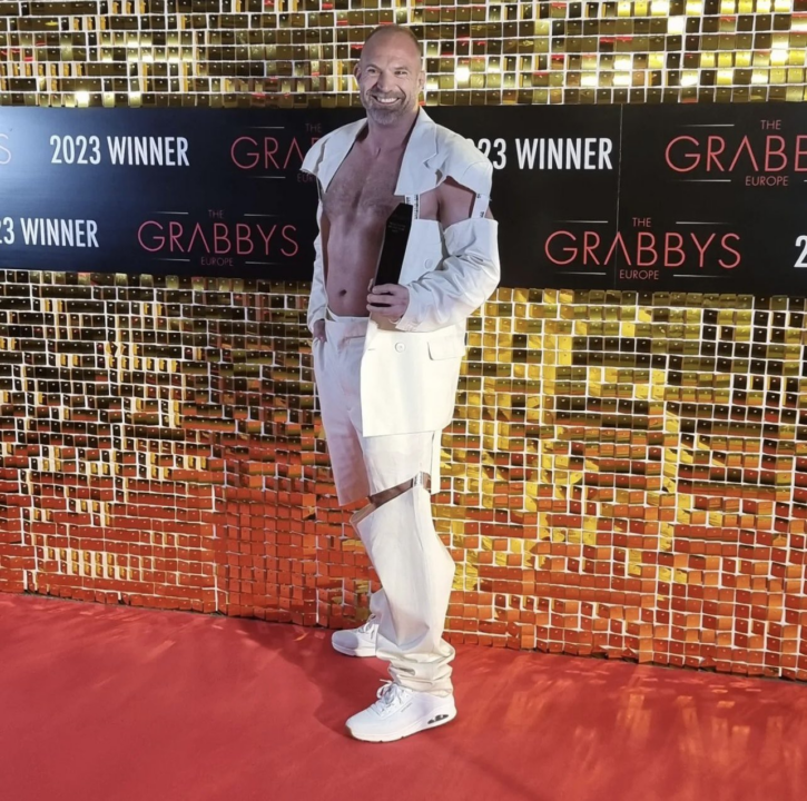 d.dan posing with award at 2023 europe grabby awards