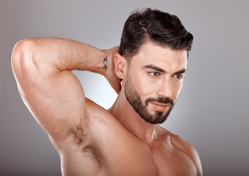gay male shirtless with beard holding up his arm behind his head to reveal his hairy armpit