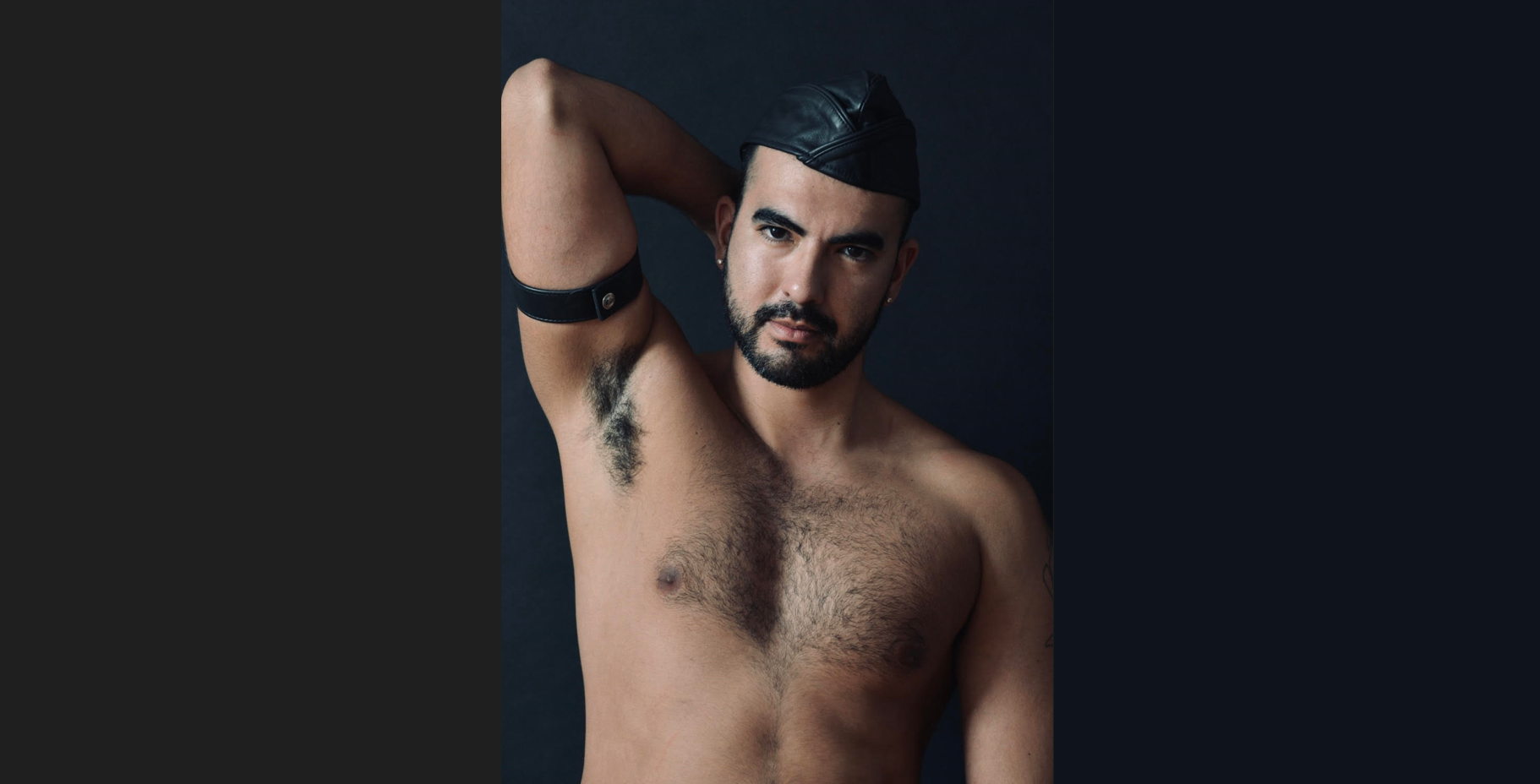 gay male posing shirtless wearing gay leather cap with his arm over his head
