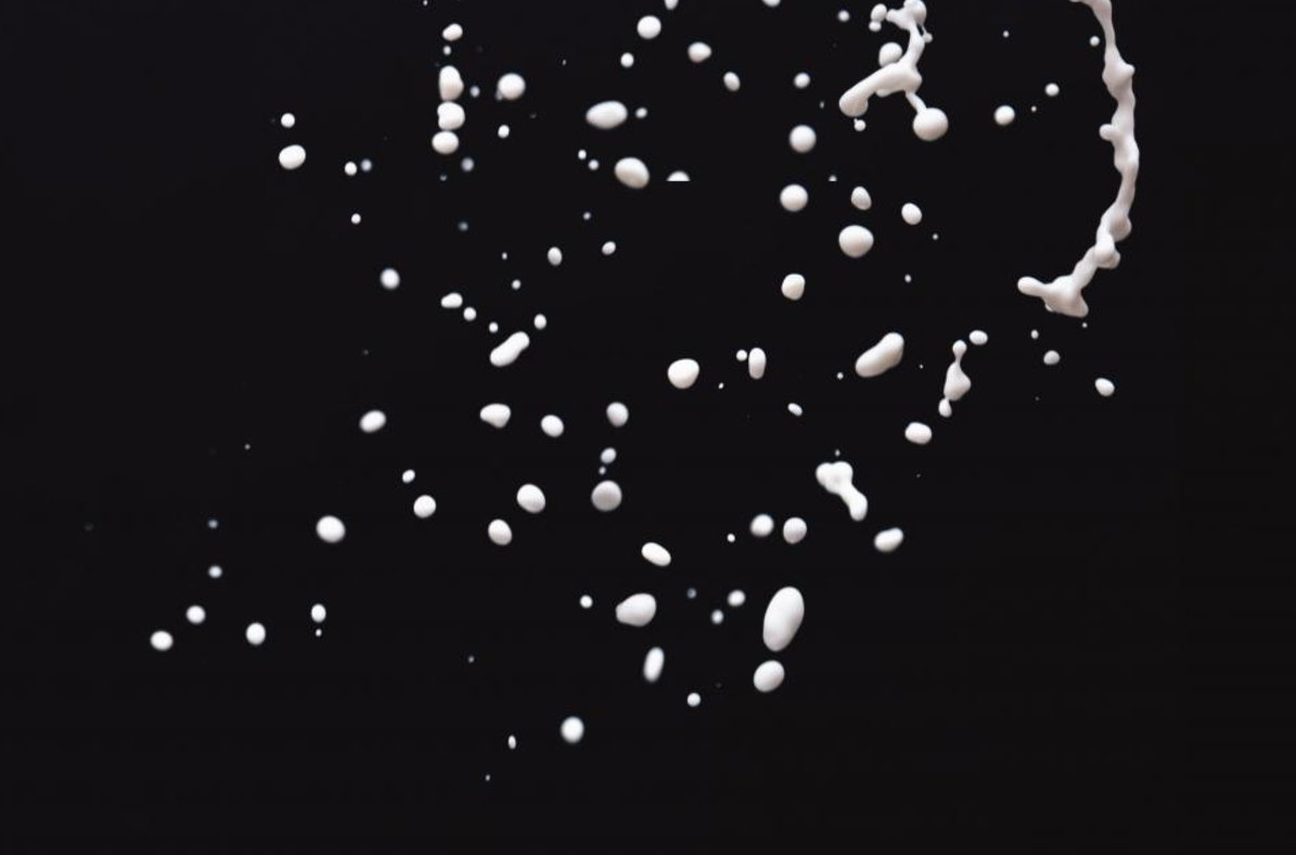 photo of white liquid substance splashing in the air against black backdrop photo by michal kulesza