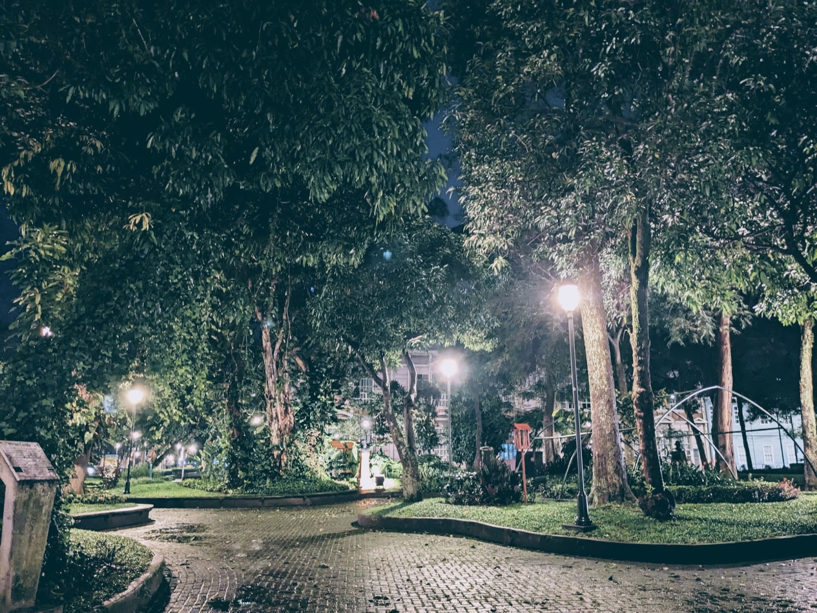 night photo of the trees and cobbled stone parkette of gay hookup gay cruising spot Parque Morazan in San Jose Costa Rica