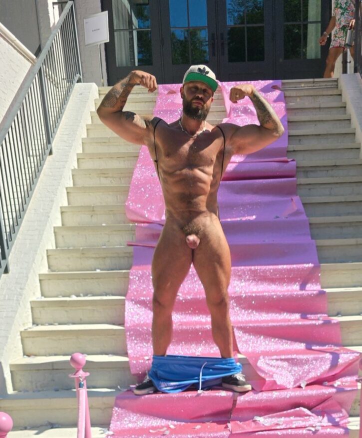 Gay porn star OnlyFans JustForFans creator Farm Dad standing fully nude outdoors, cock hard, staring down while showing off his muscles