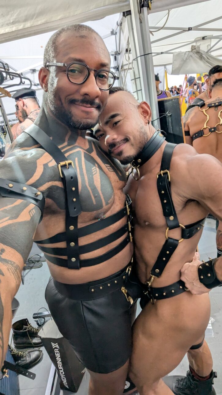 Gay porn star Amadeus wearing a leather harness and leather shorts with DefThatJason at a gay party. OnlyFans & JustForFans content creator