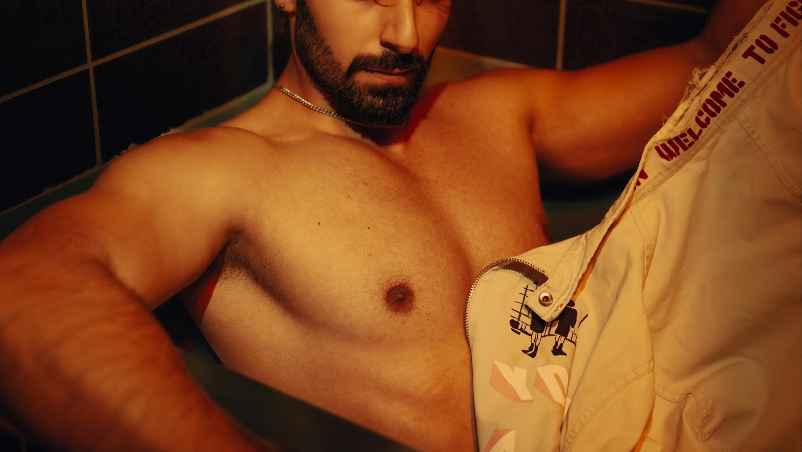 gay shirtless male sitting in a darkened room in a gay cruising bar in bogota Photo by Ömer BÜLBÜL via Pexels