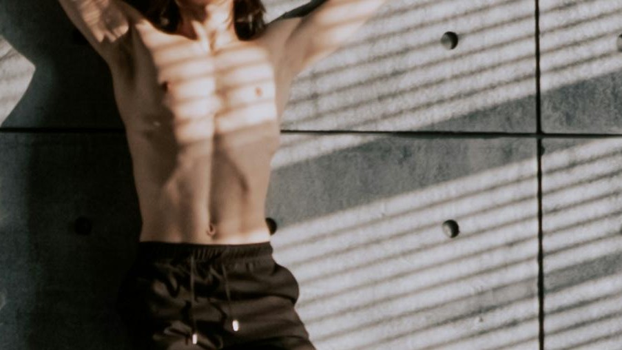 gay shirtless dancer with his back against the wall ready to have some hot and horny sex at Pucho's