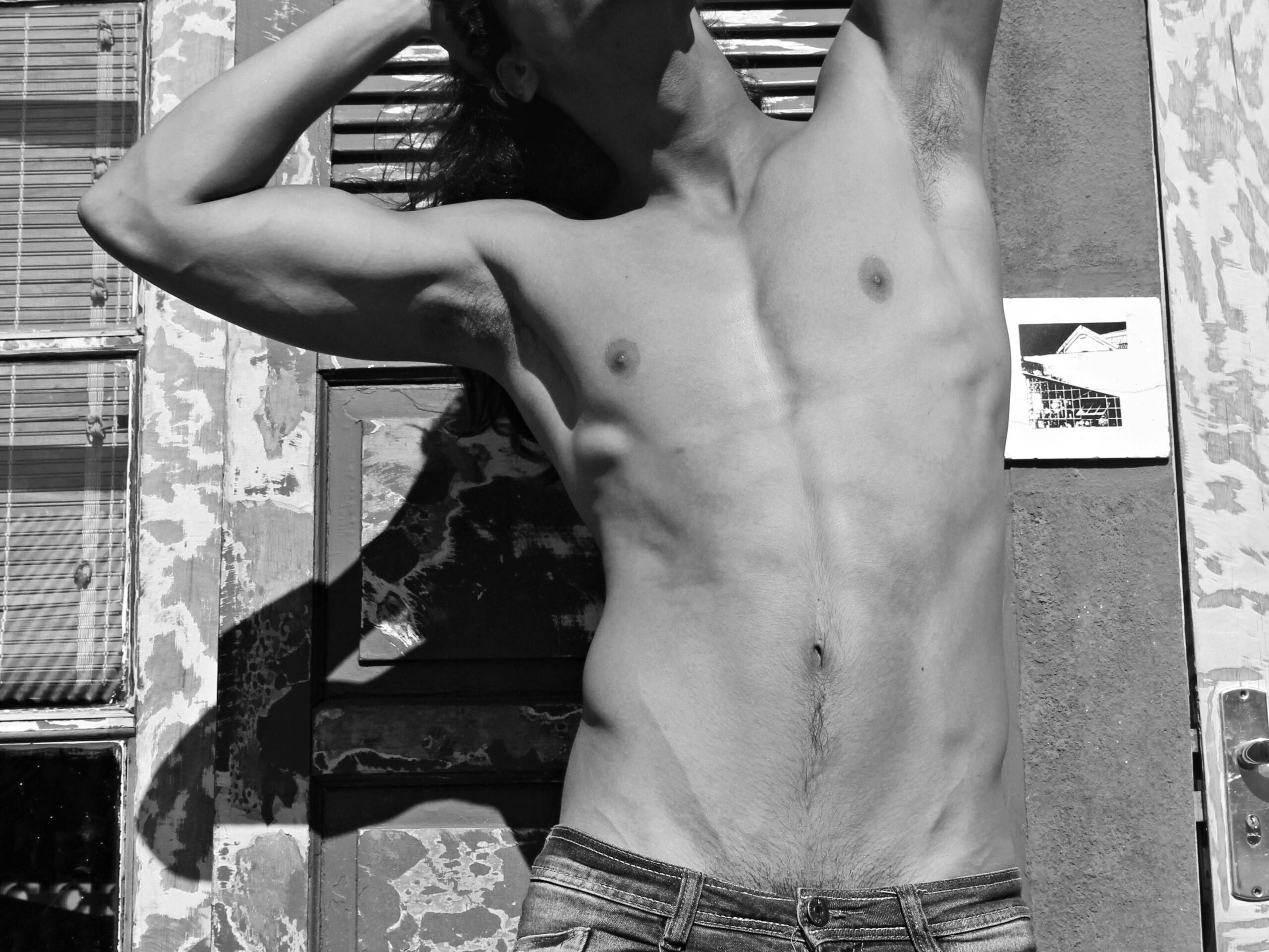 gay shirtless male posing outside Vapor Jarocho, Puerto Veracruz in Mexico Photo by Raffa Silva via Pexels