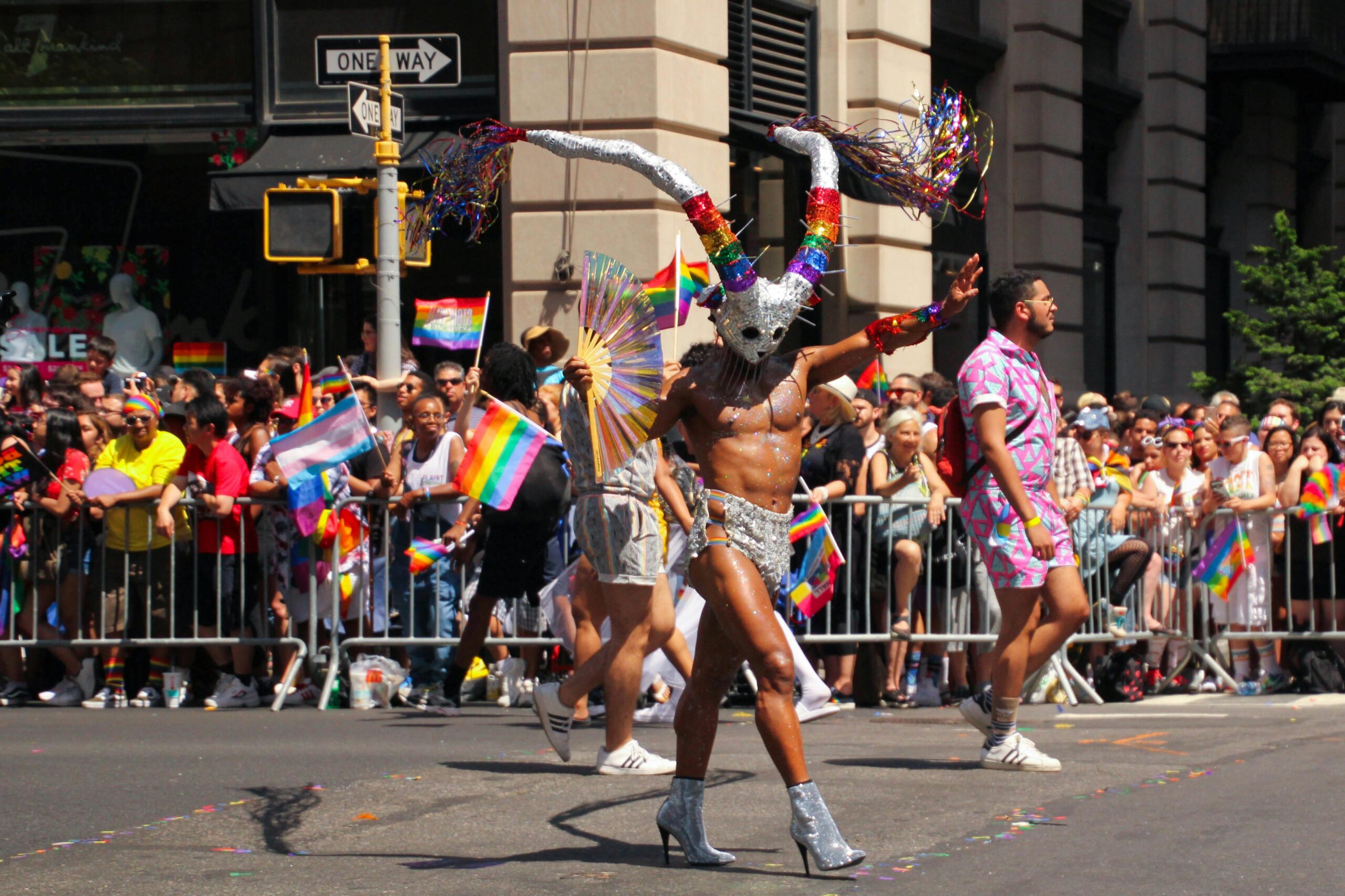 new york pride gay summer pride events around the USA gay shirtless male marching in gay pride parade via via Elvis Yang via Pexels