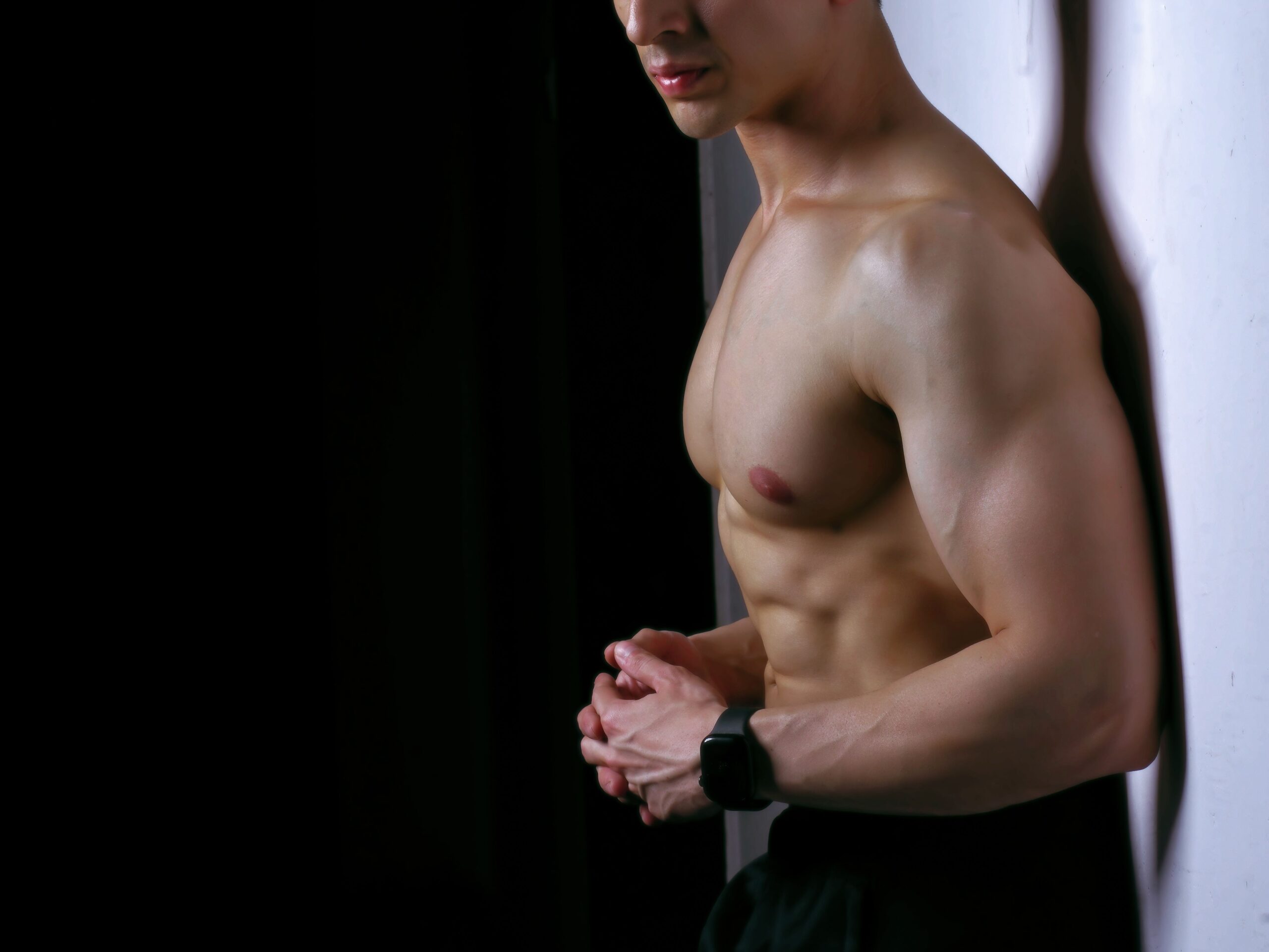 gay shirtless muscle male twink posing on the wall of a gay bathhouse sauna in the USA flex in arizona phoenix